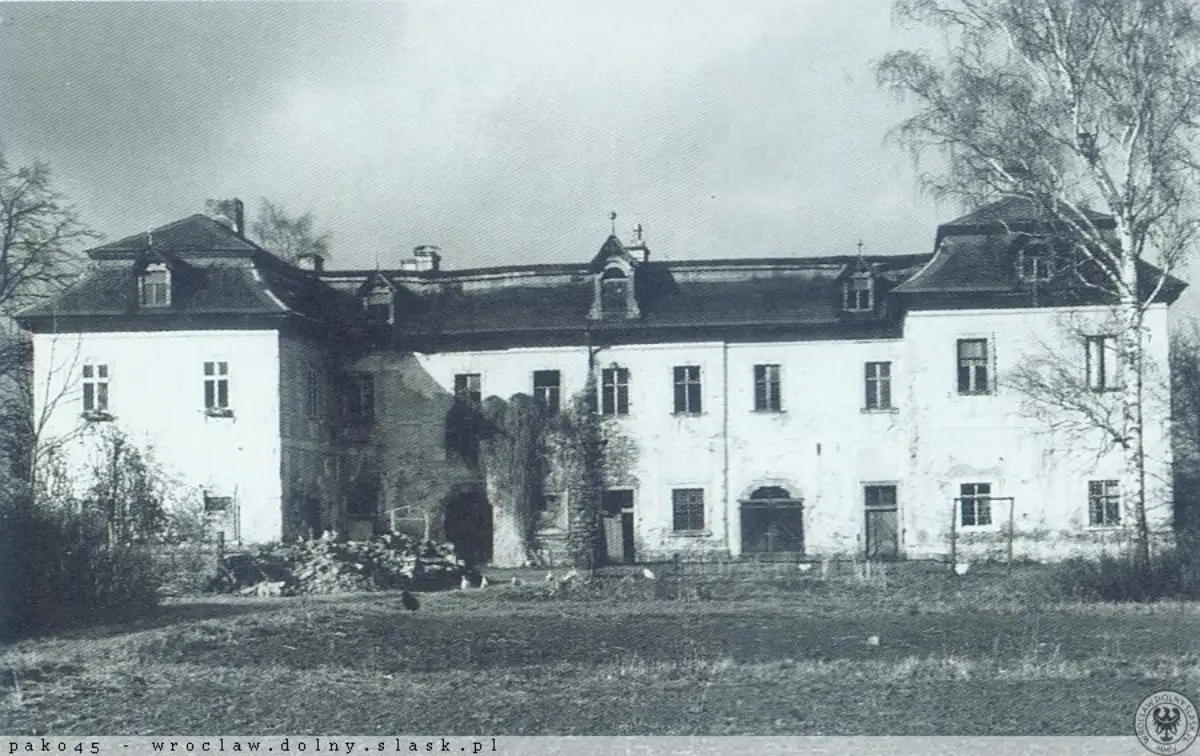 Archiwalna fotografia przedstawiająca zniszczony, pozbawiony okien i zaniedbany budynek Pałacu Pakoszów w stanie ruiny.